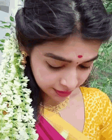 a woman with a red dot on her forehead is wearing a yellow top
