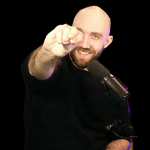 a man with a beard is smiling and giving the middle finger