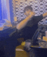 a blurry photo of a man sitting at a table talking on a cell phone