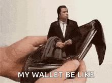 a person is holding an empty wallet with a man in a suit inside of it .