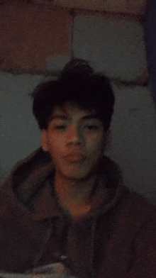 a young man in a hoodie looks at the camera