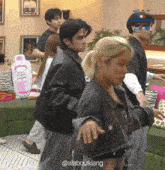 a group of people are dancing in a room with a bottle of ethyl alcohol in the background