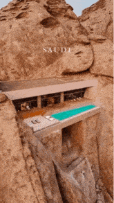 a house with a swimming pool in the middle of a rocky cliff with saudi written on the bottom