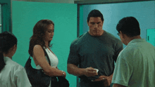 a man and a woman are standing in a hallway talking to each other