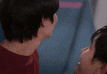 a man and a woman are looking at each other in a room .