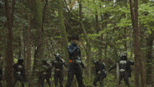 a group of people are walking through a forest with a blue light coming out of the ground
