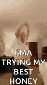 a man is dancing in a living room with the words `` i 'm trying my best honey '' written on the screen .