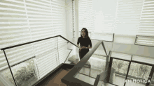 a woman is walking down a set of stairs with the words made in animatica at the bottom