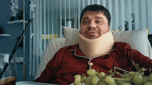 a man with a collar around his neck is sitting in a hospital bed