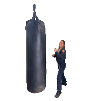 a woman is kicking a punching bag with her foot