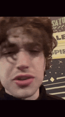 a close up of a person 's face with a sign in the background that says safe