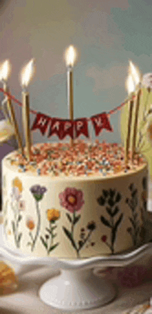 a birthday cake with candles and a banner that says happy