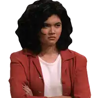 a woman with curly hair wearing a red jacket and white shirt