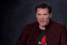 a man wearing a rolling stones shirt is making a funny face
