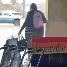 a woman in a pink backpack is walking in front of a sign that says amarillo pride