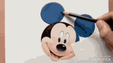 a person is drawing mickey mouse on a piece of paper with a pencil