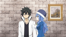 a man and a woman standing in front of a brick wall