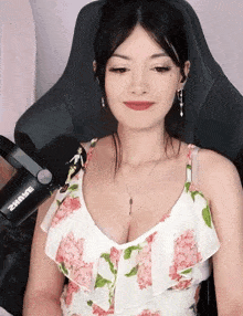 a woman is sitting in a chair in front of a shure microphone .