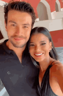 a man and woman are posing for a picture and the woman is smiling