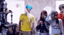 a group of people are standing in a room and one of them is wearing a yellow shirt with the number 1 on it
