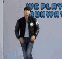 a man in a varsity jacket is dancing in front of a sign that says we play runway .
