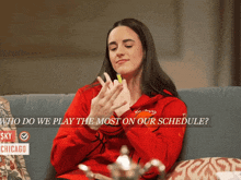 a woman sitting on a couch with the words who do we play the most on our schedule behind her