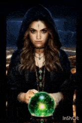 a woman in a black robe is holding a crystal ball with the word malefica written on it