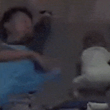 a blurry picture of a person sitting on a couch with a stuffed animal .