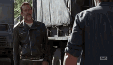 a man in a leather jacket is standing next to another man and the word service is above him