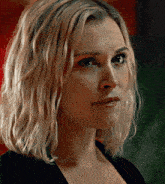 a close up of a woman 's face with blonde hair and a black top