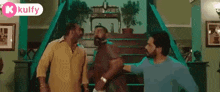 a group of men are standing next to each other in a living room .