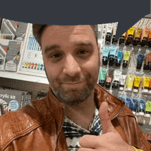 a man in a brown leather jacket is giving a thumbs up