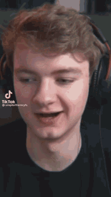 a close up of a man wearing headphones and a black shirt