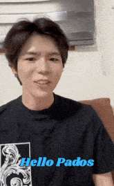 a man wearing a black shirt with the words hello pados on it