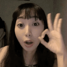 a woman is making an okay sign with her hand