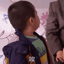 a young boy wearing a blue jacket and a green shirt with the word ballast on it