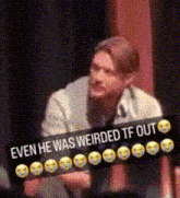 a man is holding a sign that says even he was weirded tf out .