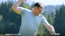 a man in a blue shirt is throwing a frisbee and the nbc logo is visible