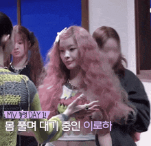 a girl with pink hair is standing in front of a sign that says mv day 1