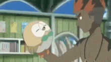 a man is holding a small owl in his hands while standing next to another man .