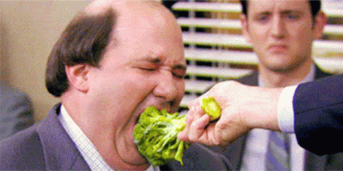 A man eating broccoli forcefully