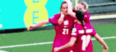 a group of soccer players are hugging each other on the field .