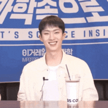 a man is smiling in front of a sign that says t's science ins
