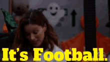 a woman stands in front of a sign that says ' it 's football '