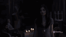 a woman is standing in a dark room with abc family hd written on the bottom right