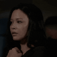 a close up of a woman 's face with long black hair