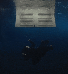 a person is swimming underwater with a door visible in the background