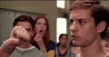a group of people are standing around a man in a room .