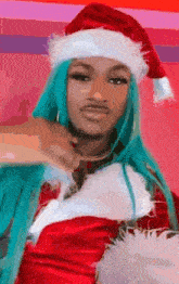 a woman with blue hair and a santa hat on