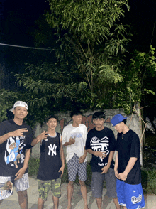 a group of young men wearing ny shirts and dodgers shorts pose for a picture